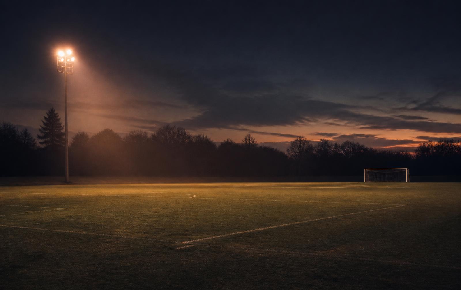 Campo da calcio illuminato al tramonto